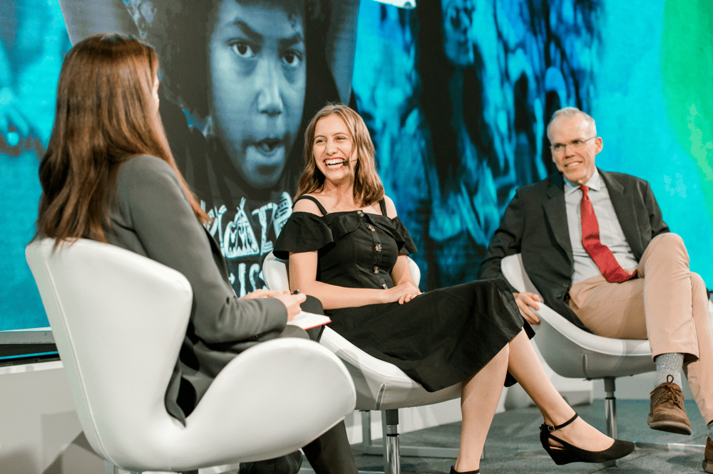 One man and two women speaking on a stage
